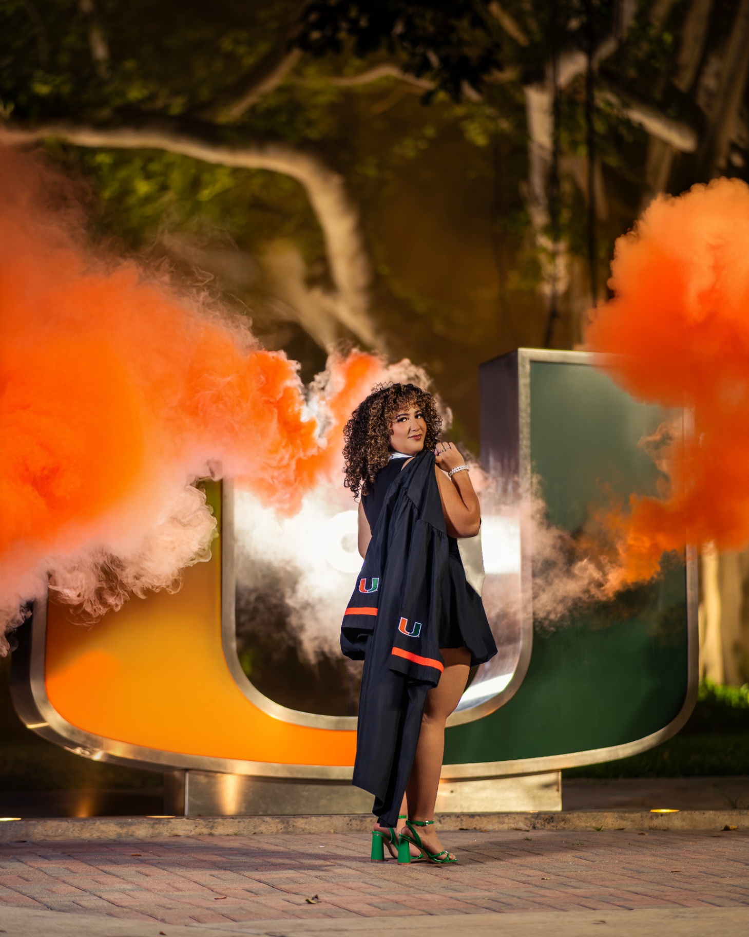 Miami grad with orange smoke at the U statue