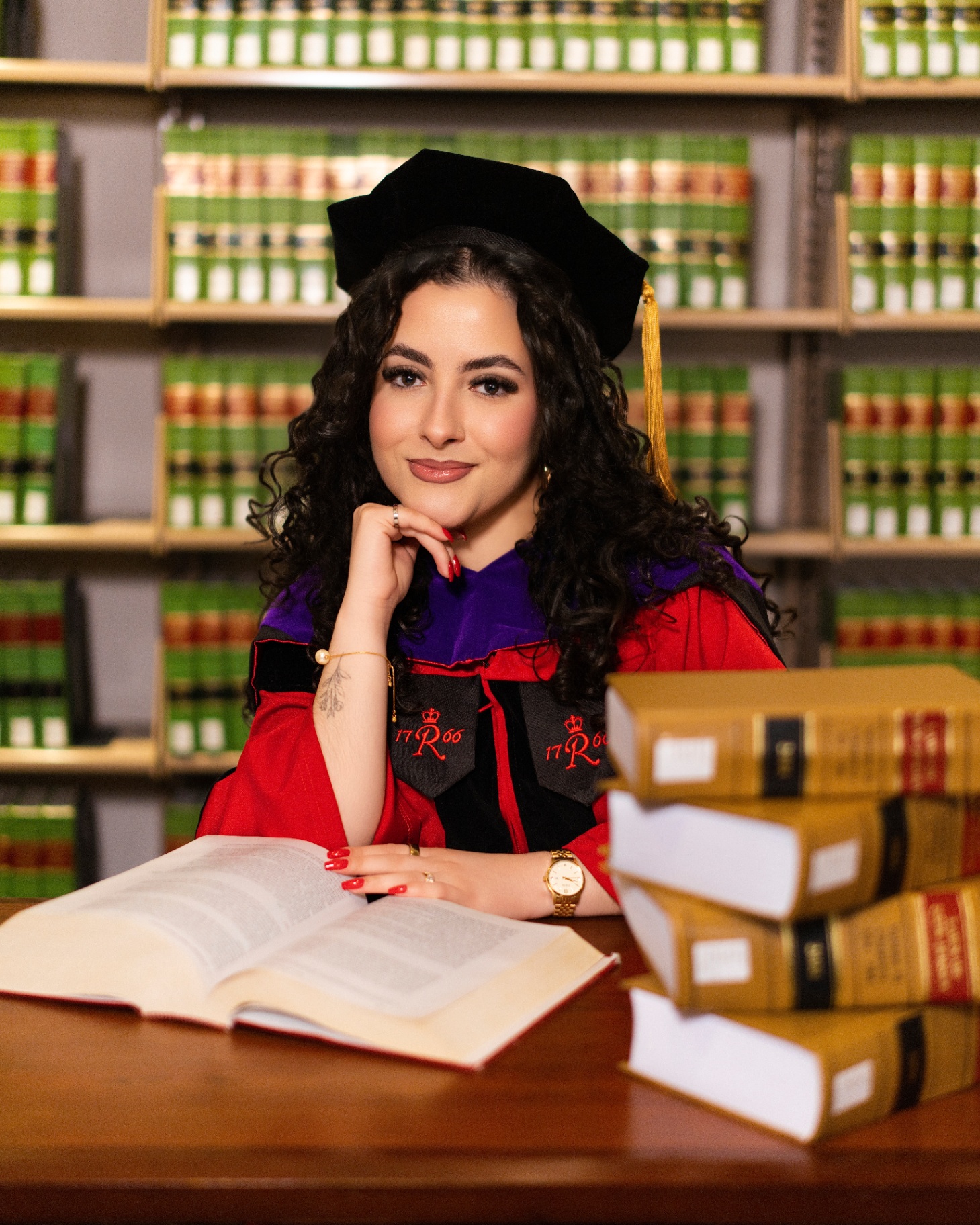 Rutgers Law JD grad in red robe with law books