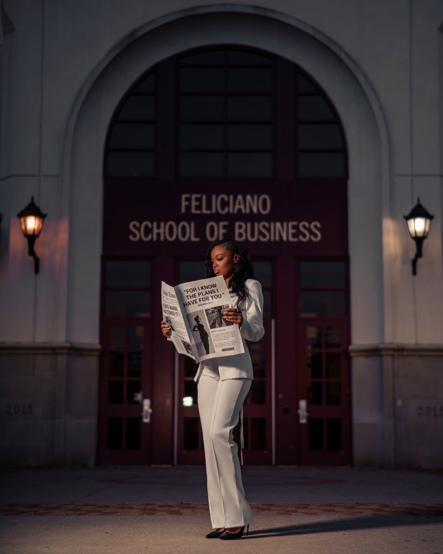MBA grad reading newspaper outside Feliciano School