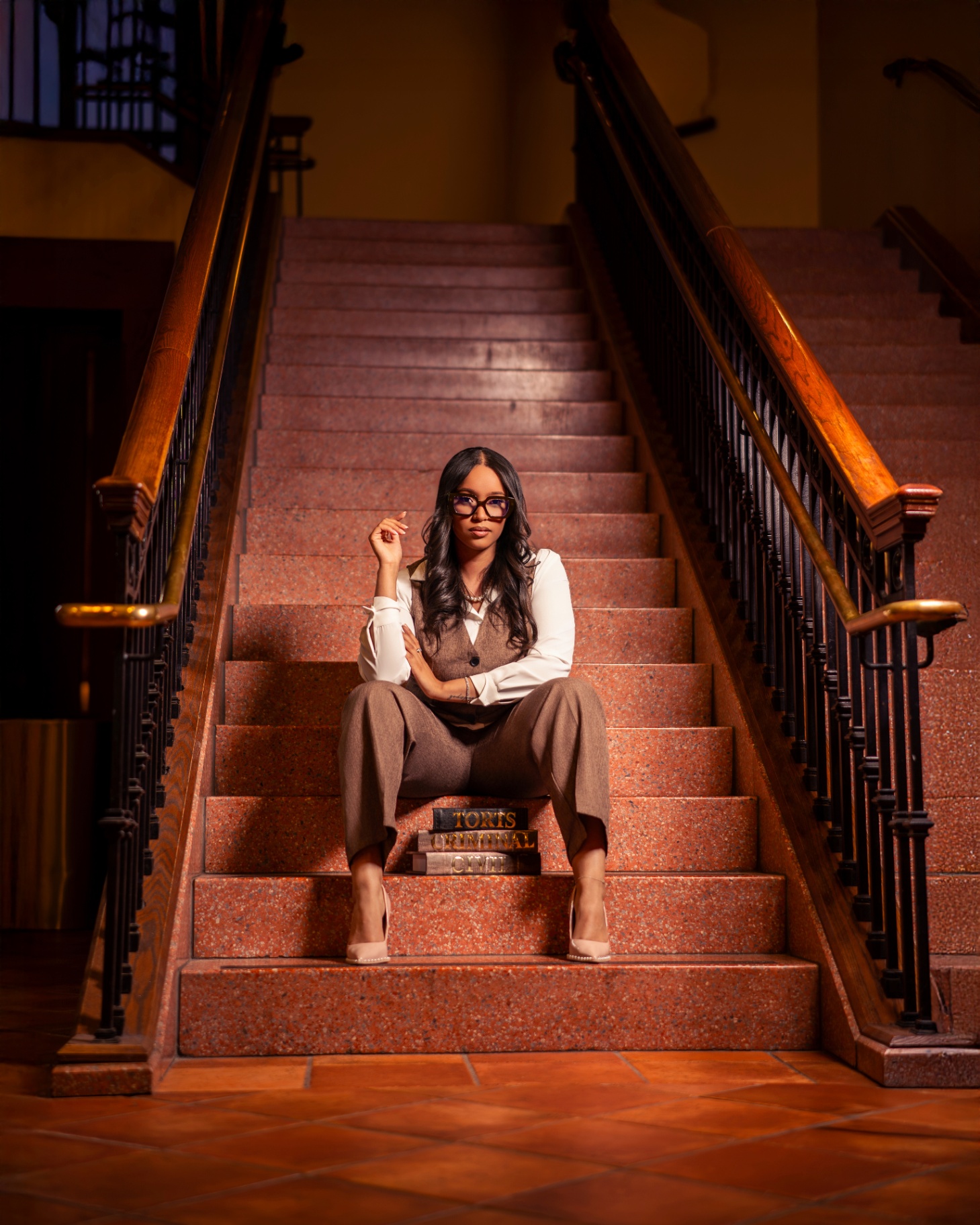 Law student posing on staircase with law textbooks