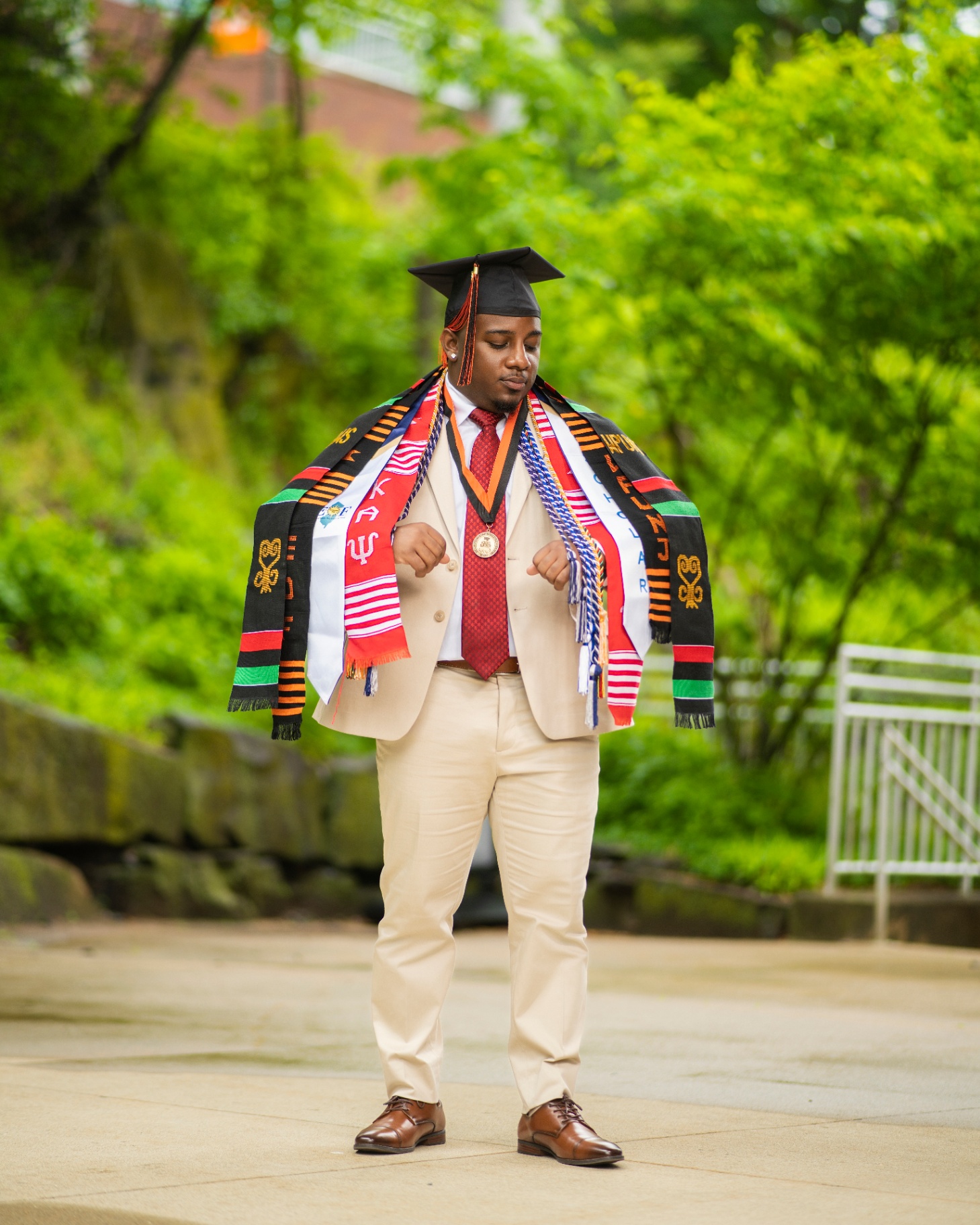 Grad draped in Kente stoles and honor cords outdoors