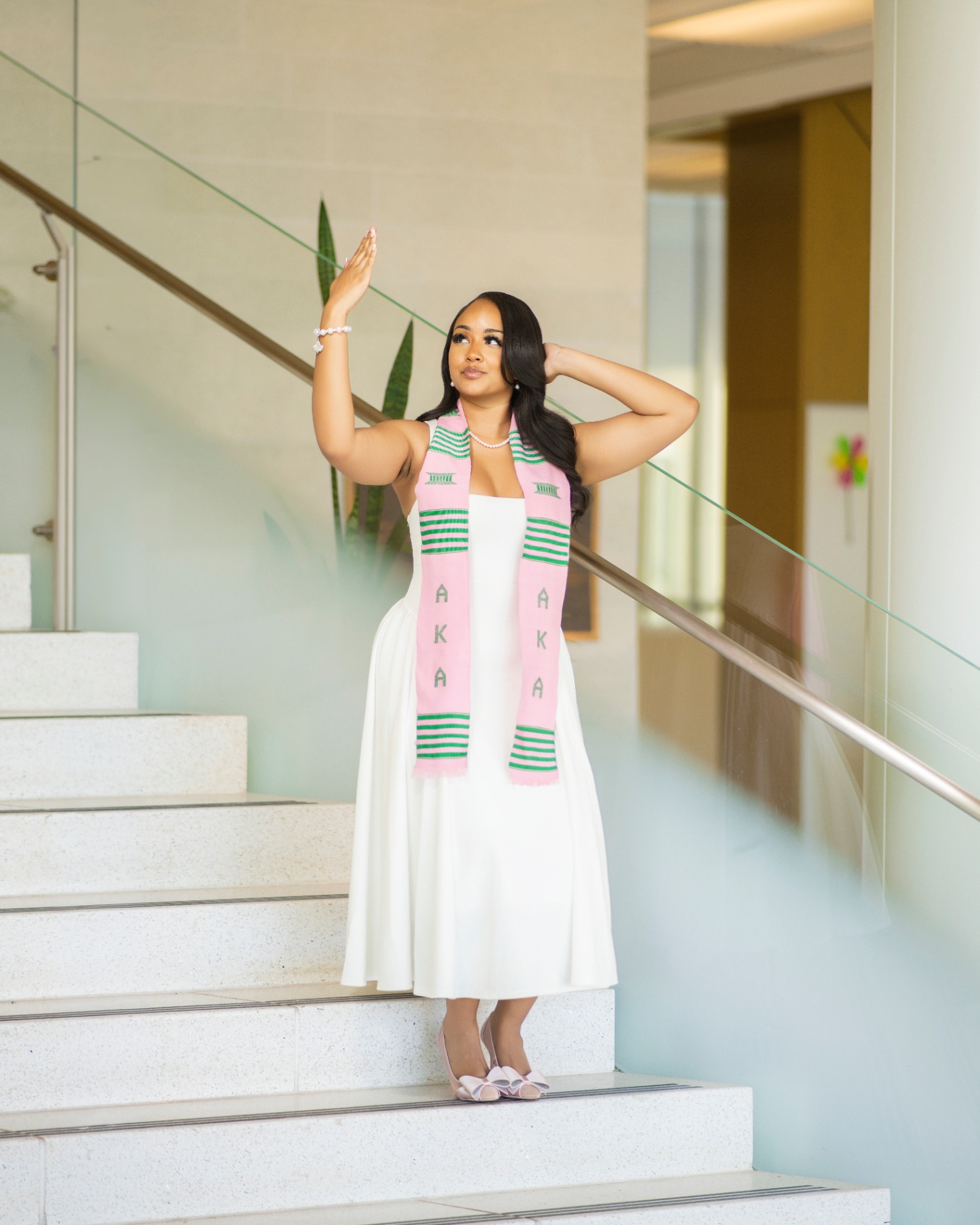 AKA grad in white dress on modern staircase