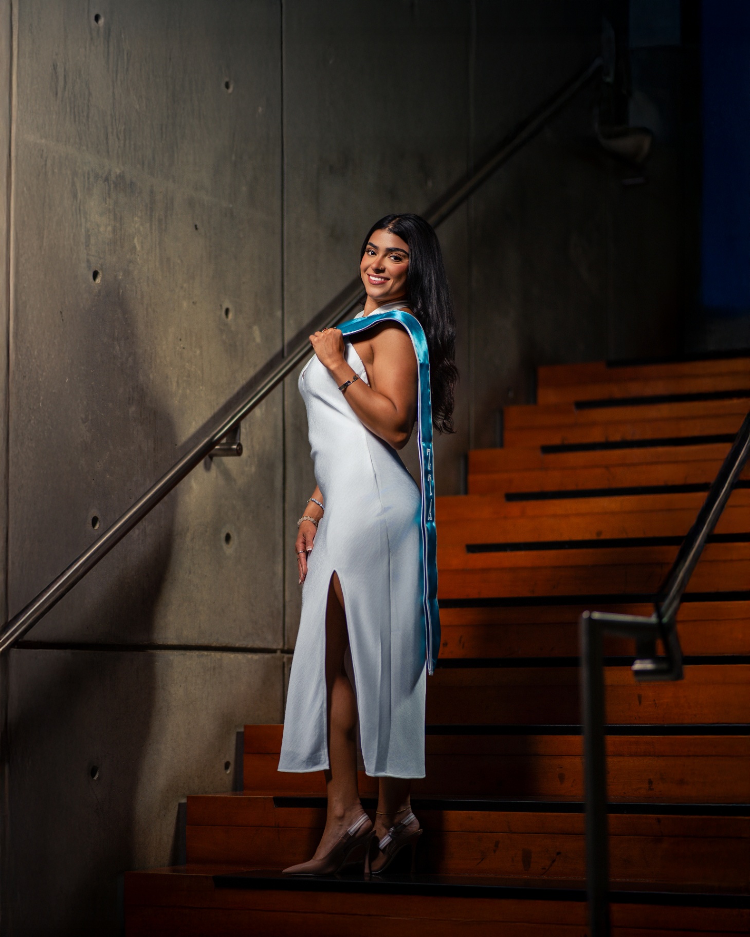 ZTA grad in white dress on modern staircase
