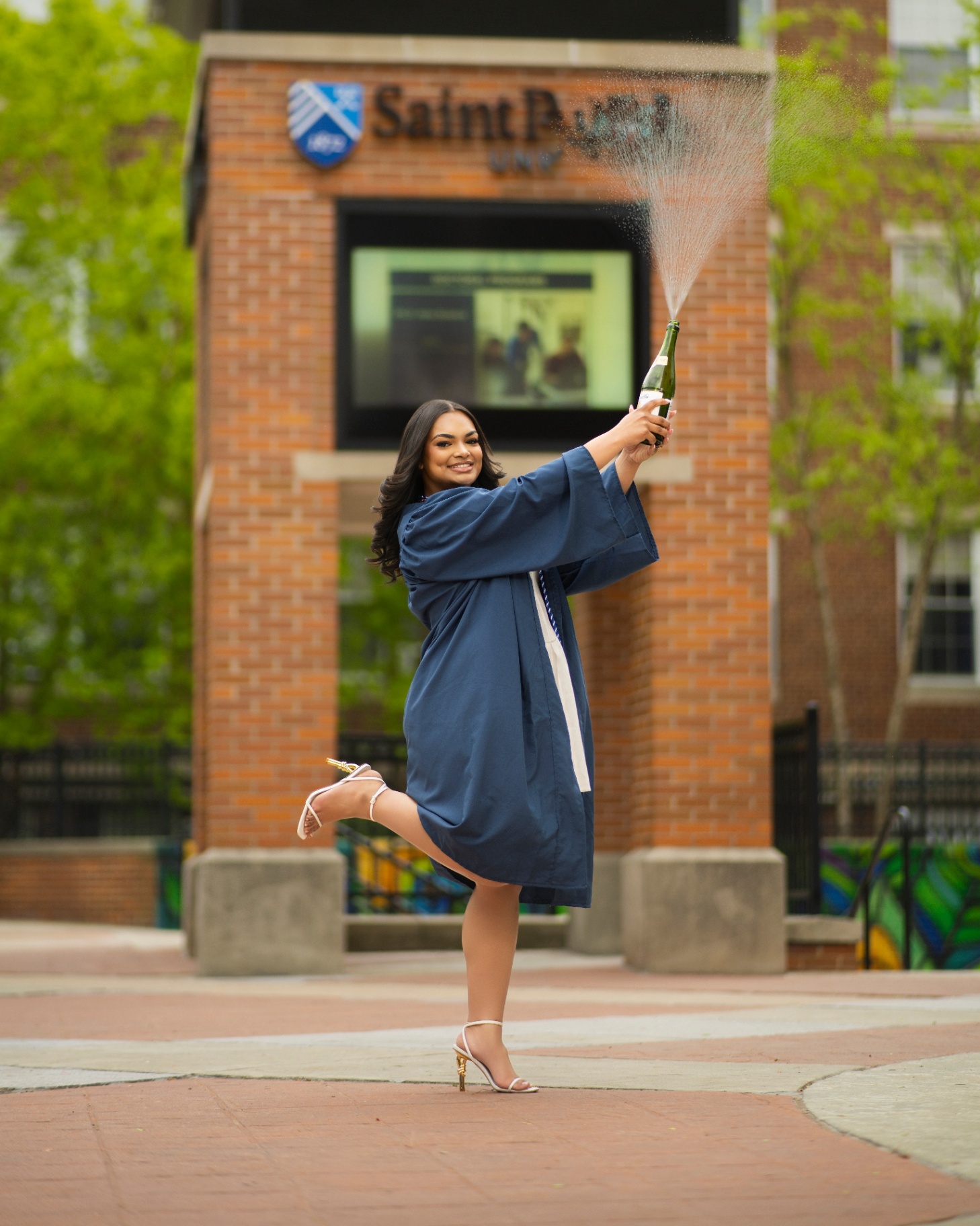 Saint Peter's grad popping champagne on campus