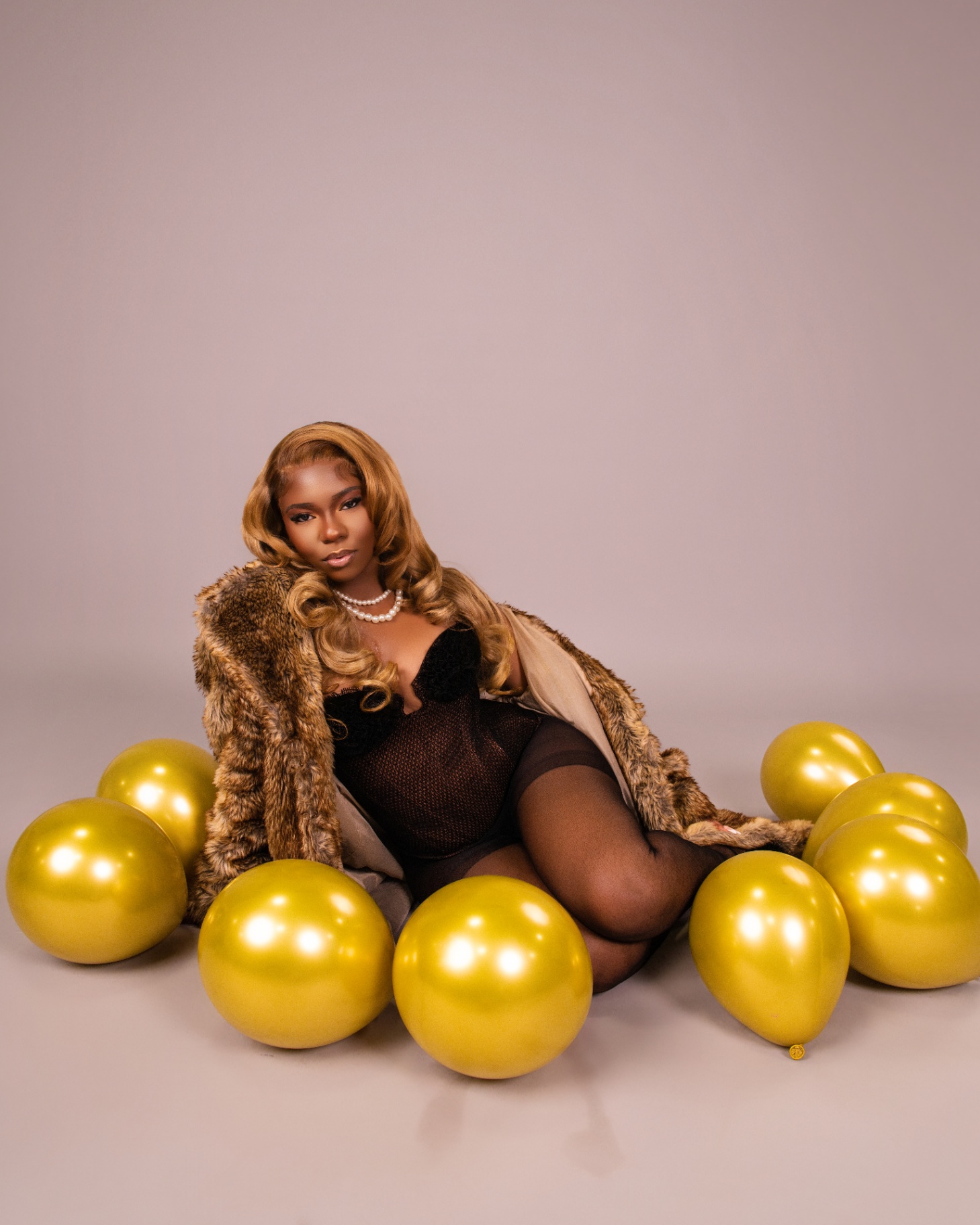 Fur coat portrait with gold balloons