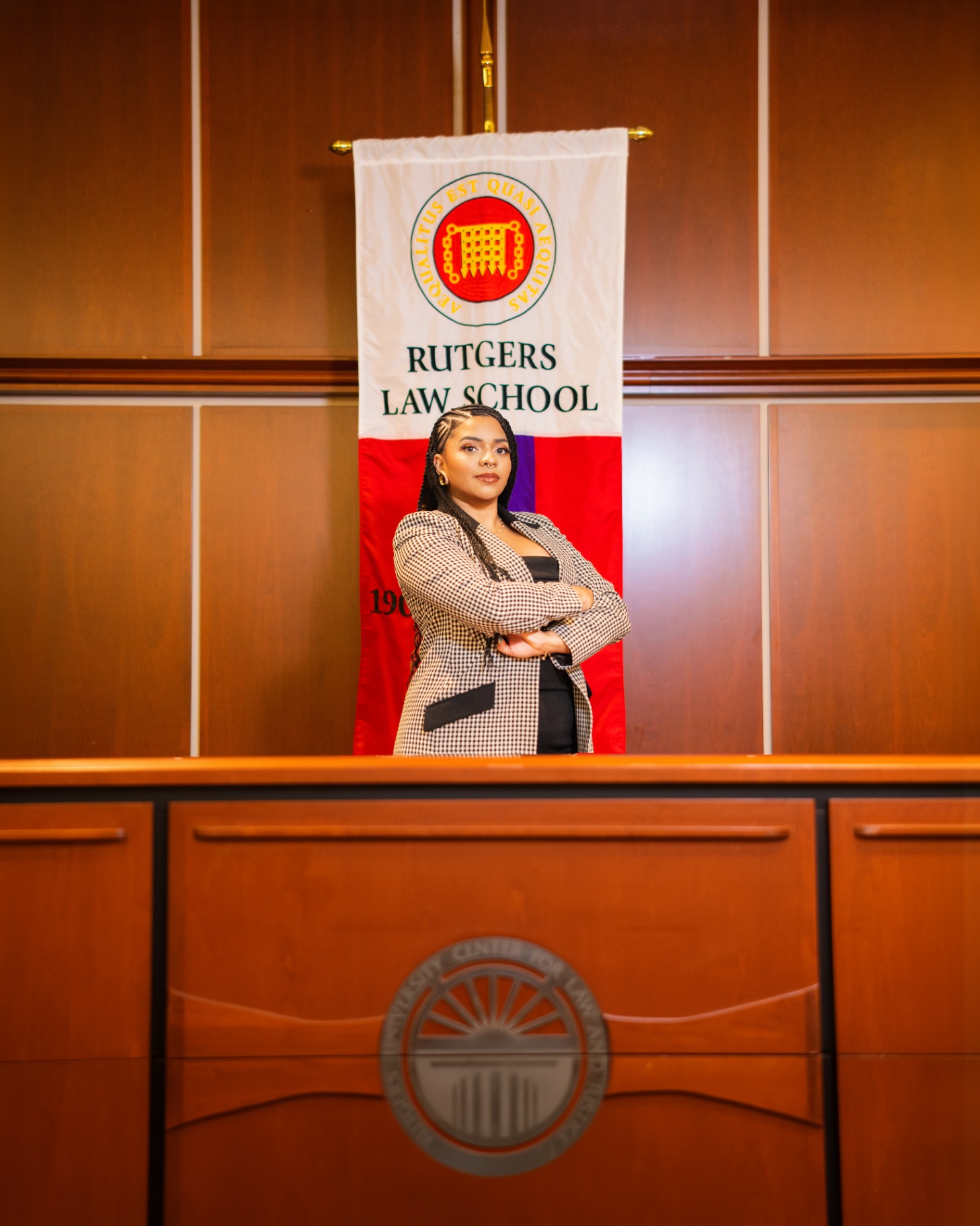 Rutgers Law grad posing in front of school banner