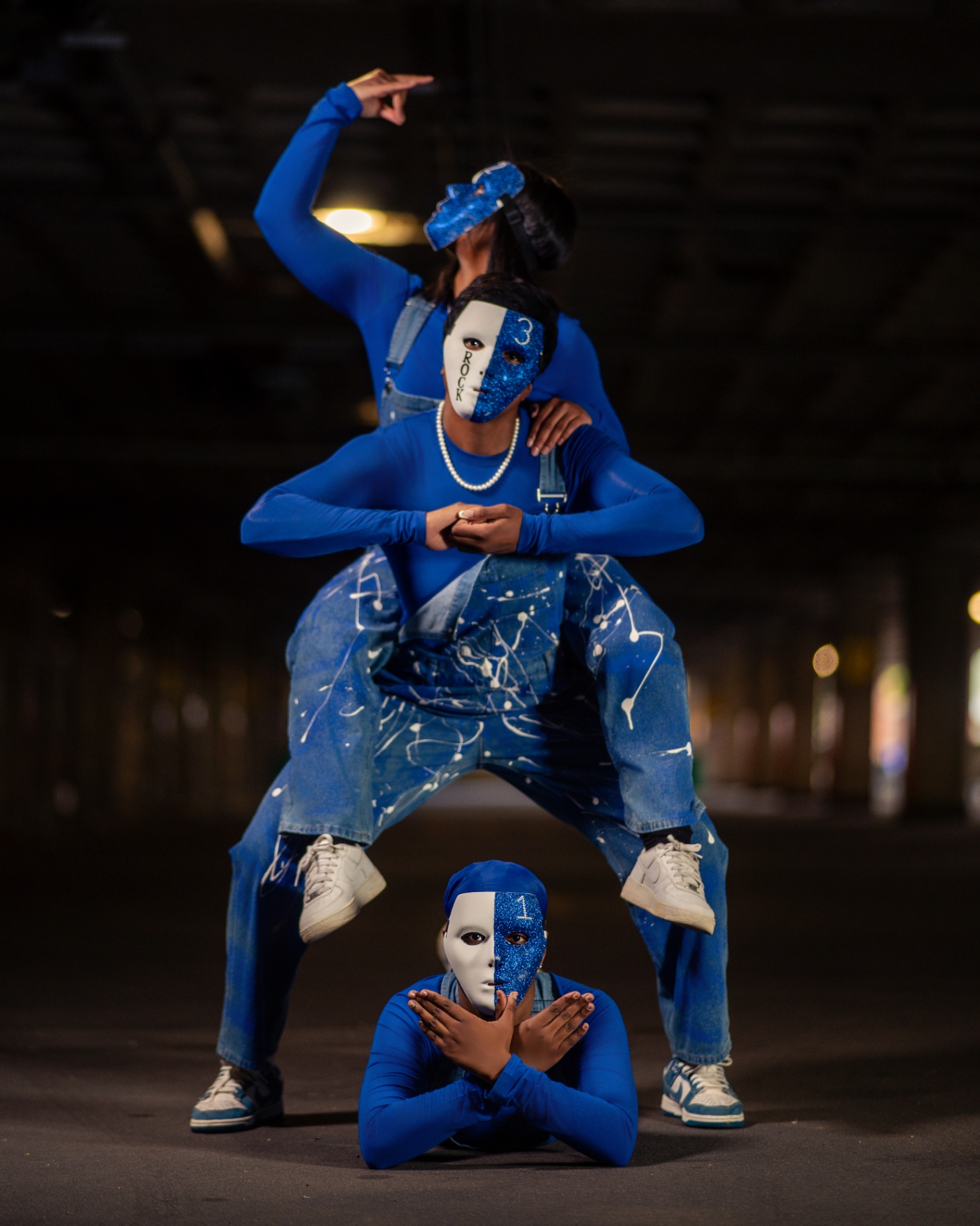 Blue mask crew stacked pose in parking garage