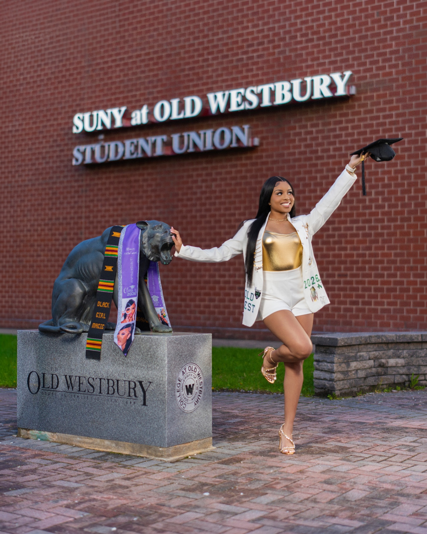 SUNY Old Westbury grad by panther statue