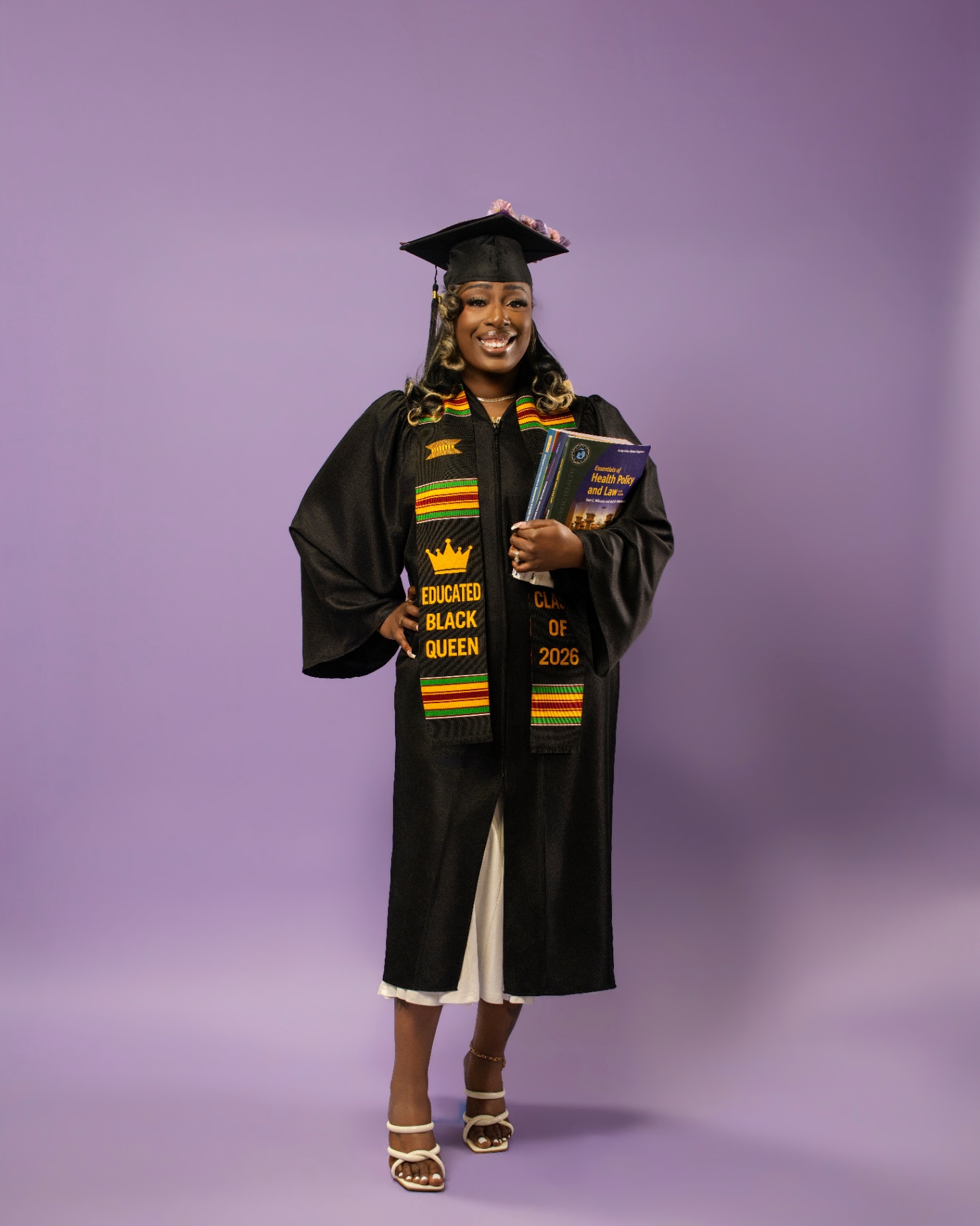 Educated Black Queen grad on purple studio backdrop