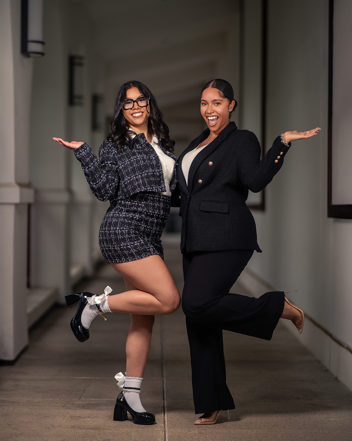 Business duo playful pose in campus corridor