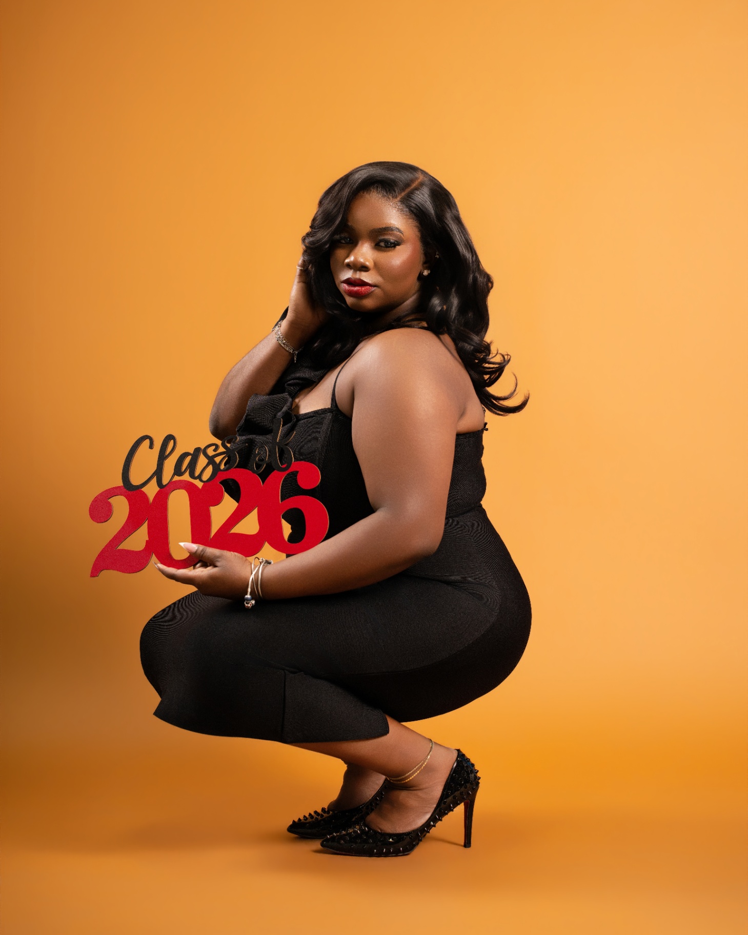 Class of 2026 studio portrait — orange backdrop
