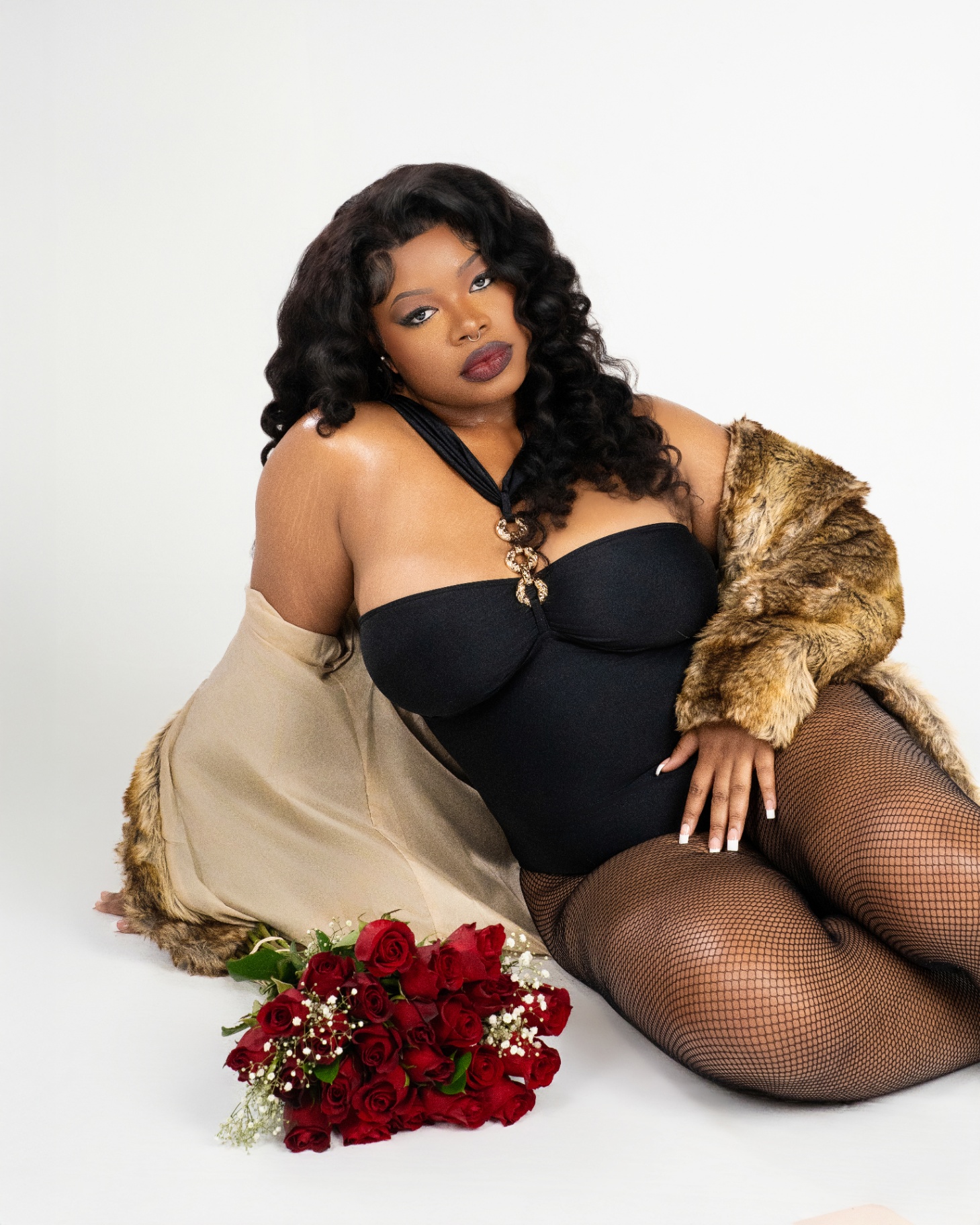 Seated portrait in black bodysuit with fur and roses