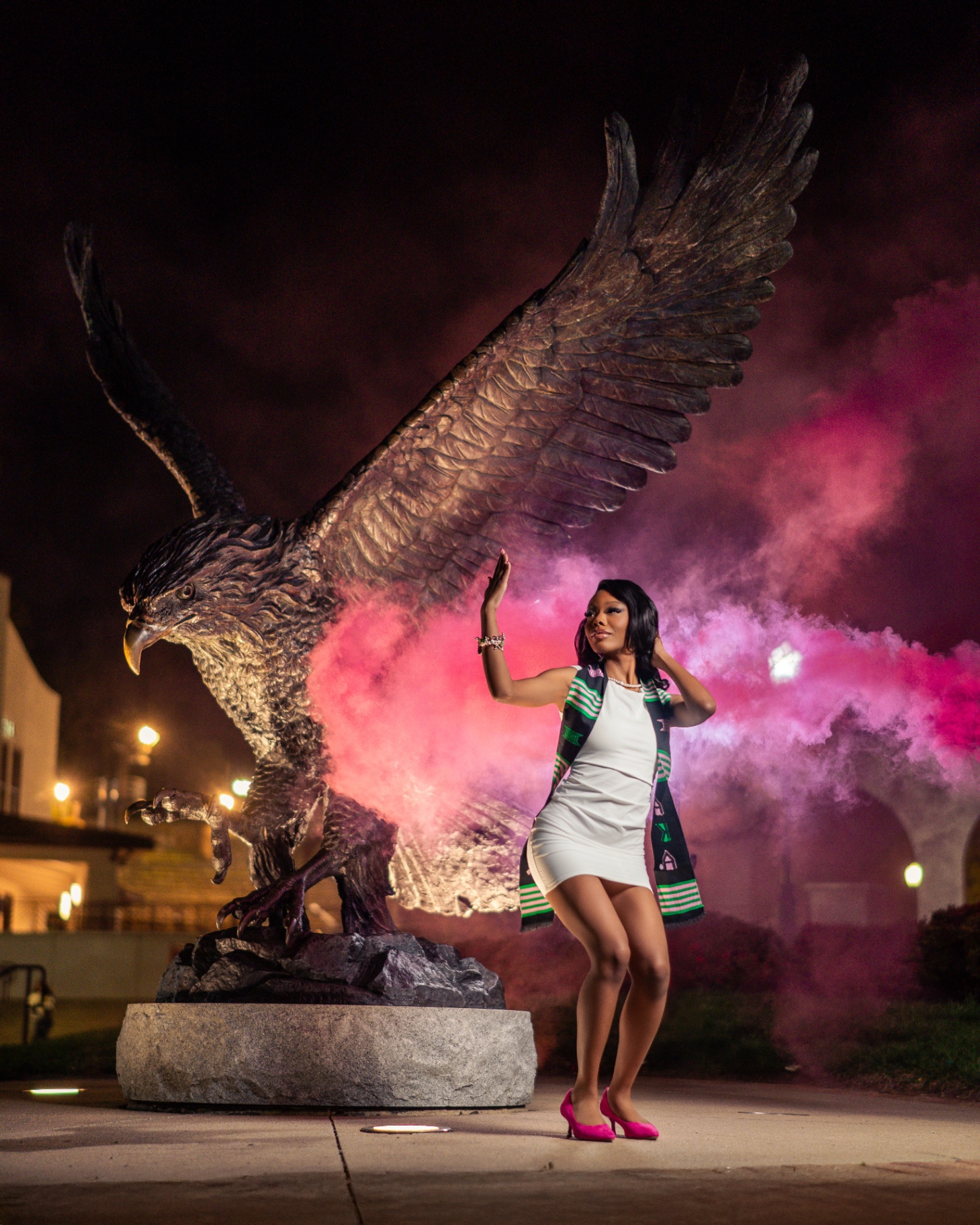 AKA graduate with pink smoke by eagle statue