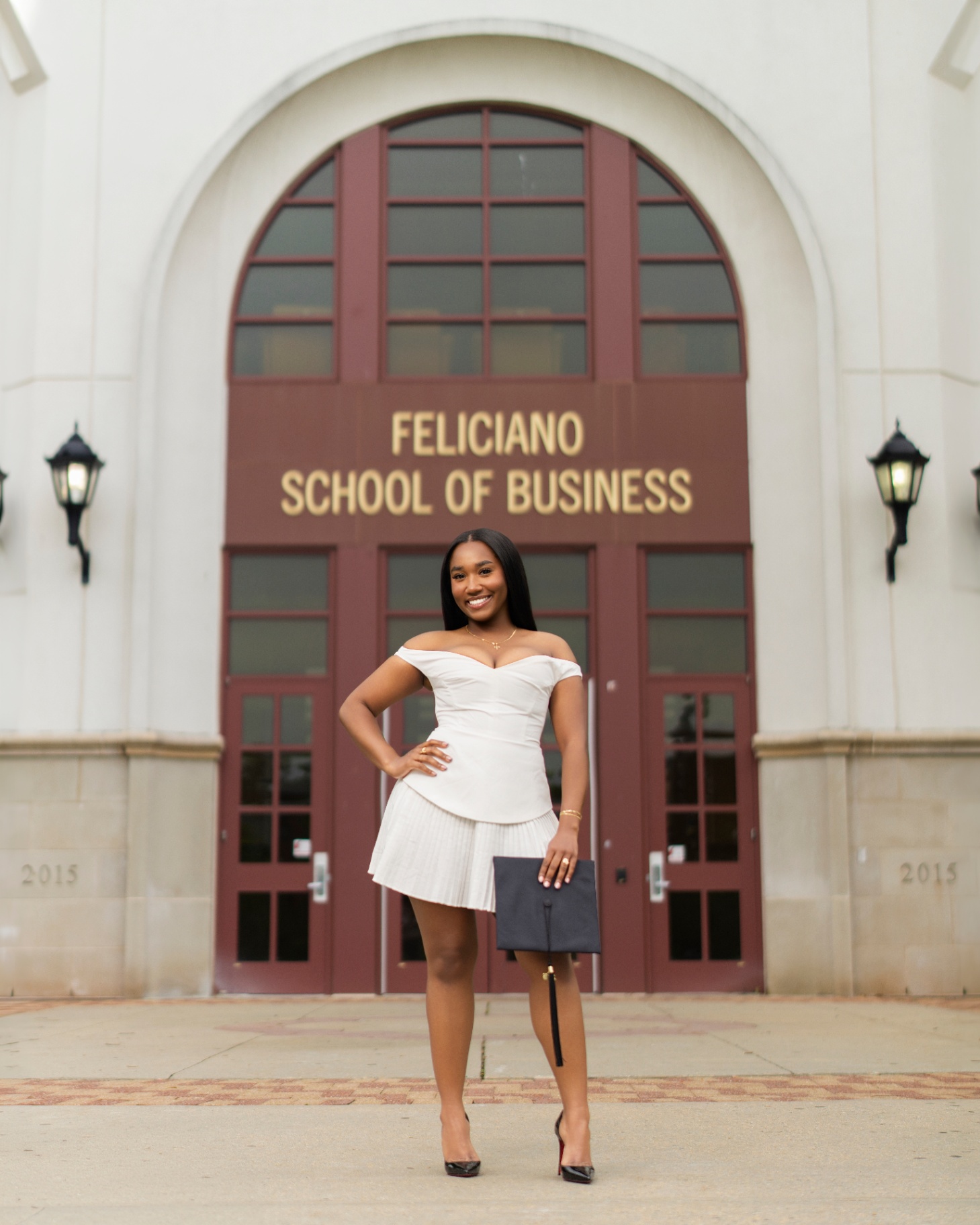 Grad in white dress at Feliciano School of Business
