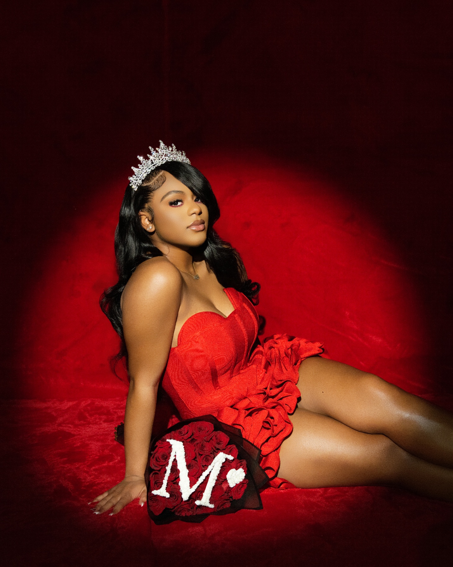 Red backdrop tiara portrait with rose bouquet
