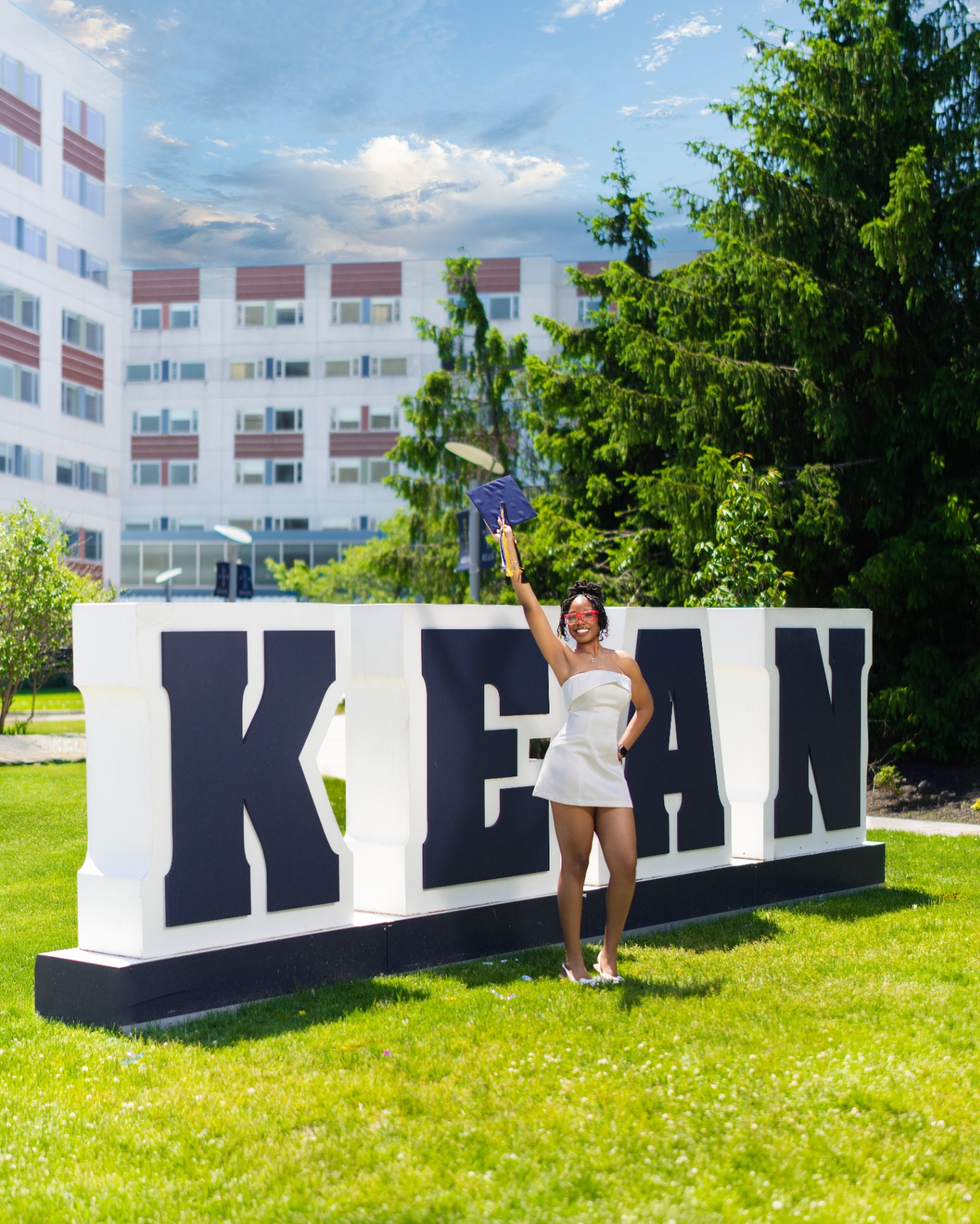 Graduate cheering at Kean sign
