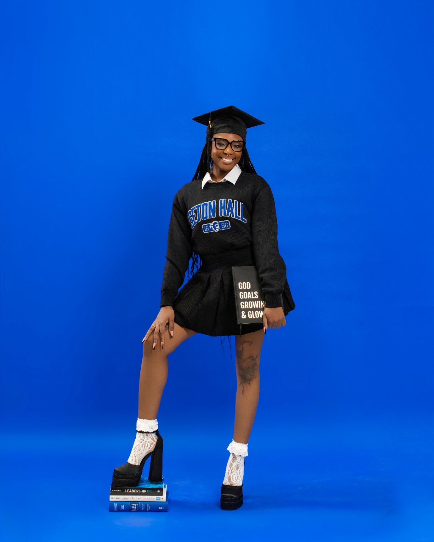 Seton Hall grad in prep-school look on blue backdrop