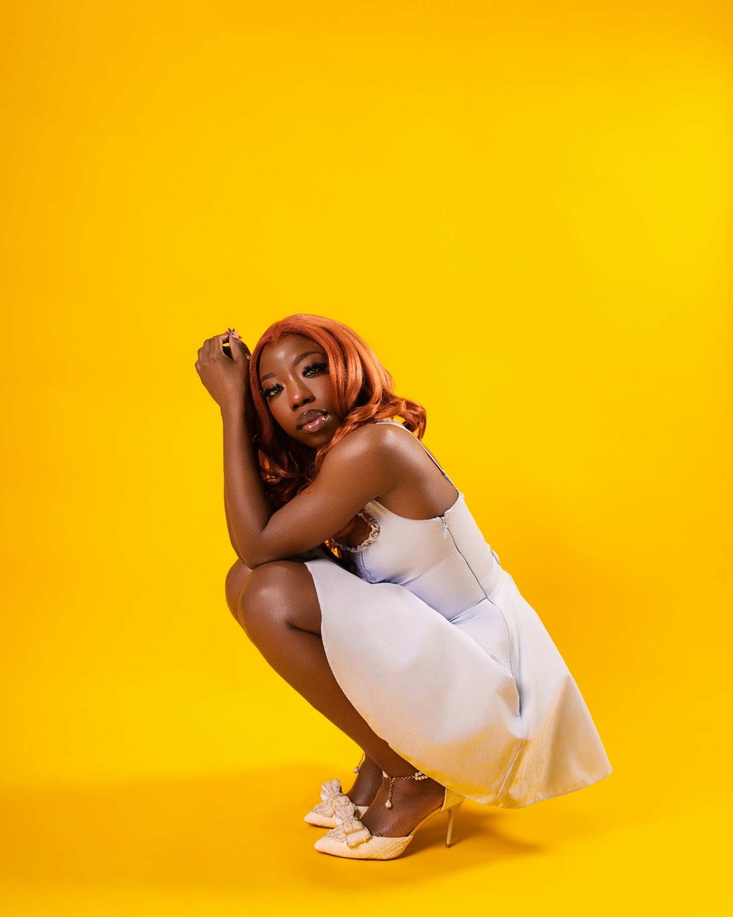 Ginger hair crouched portrait on yellow