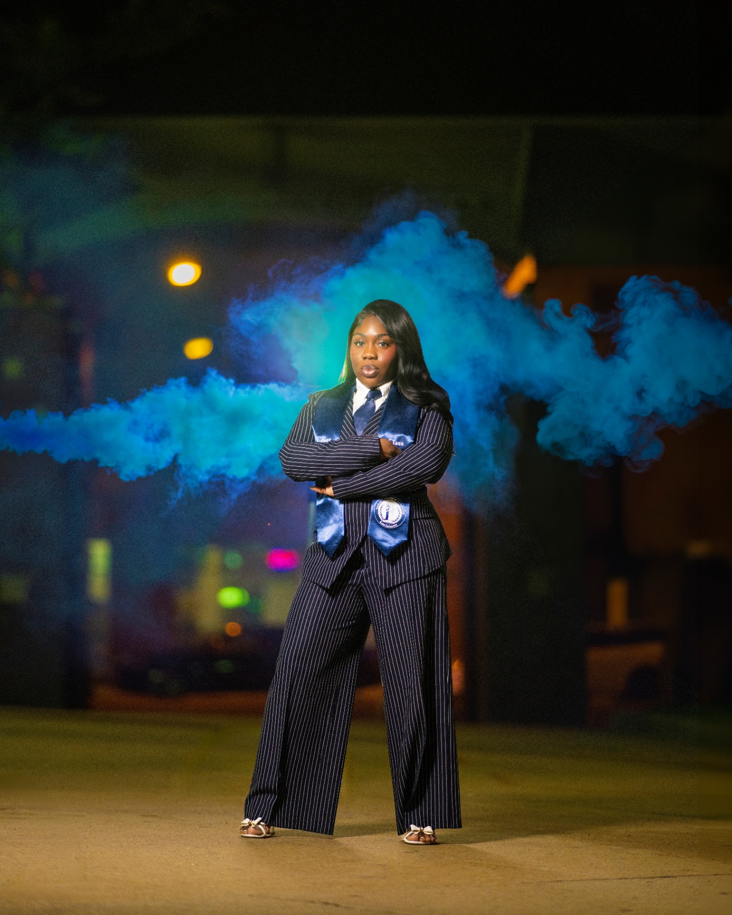 Pinstripe suit grad with blue smoke at night